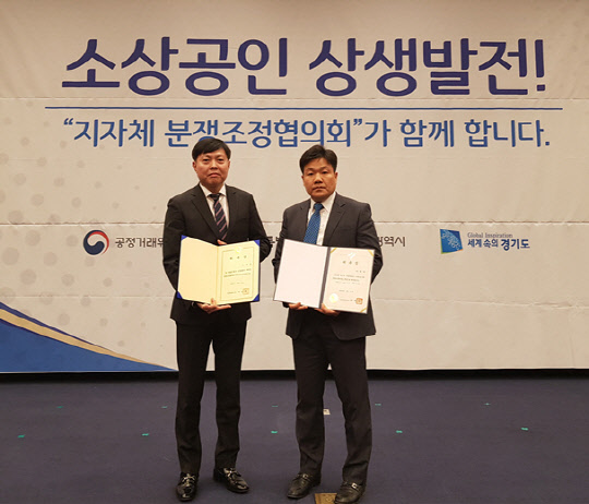 11일 서울 국회 헌정기념관 대강당에서 열린 지자체 가맹·대리점 분쟁조정협의회 합동 출범식에서 전국이동통신유통협회 송수걸 이사(왼쪽)와 박대학 부회장이 기념촬영을 하고 있다. 전국이동통신유통협회 제공